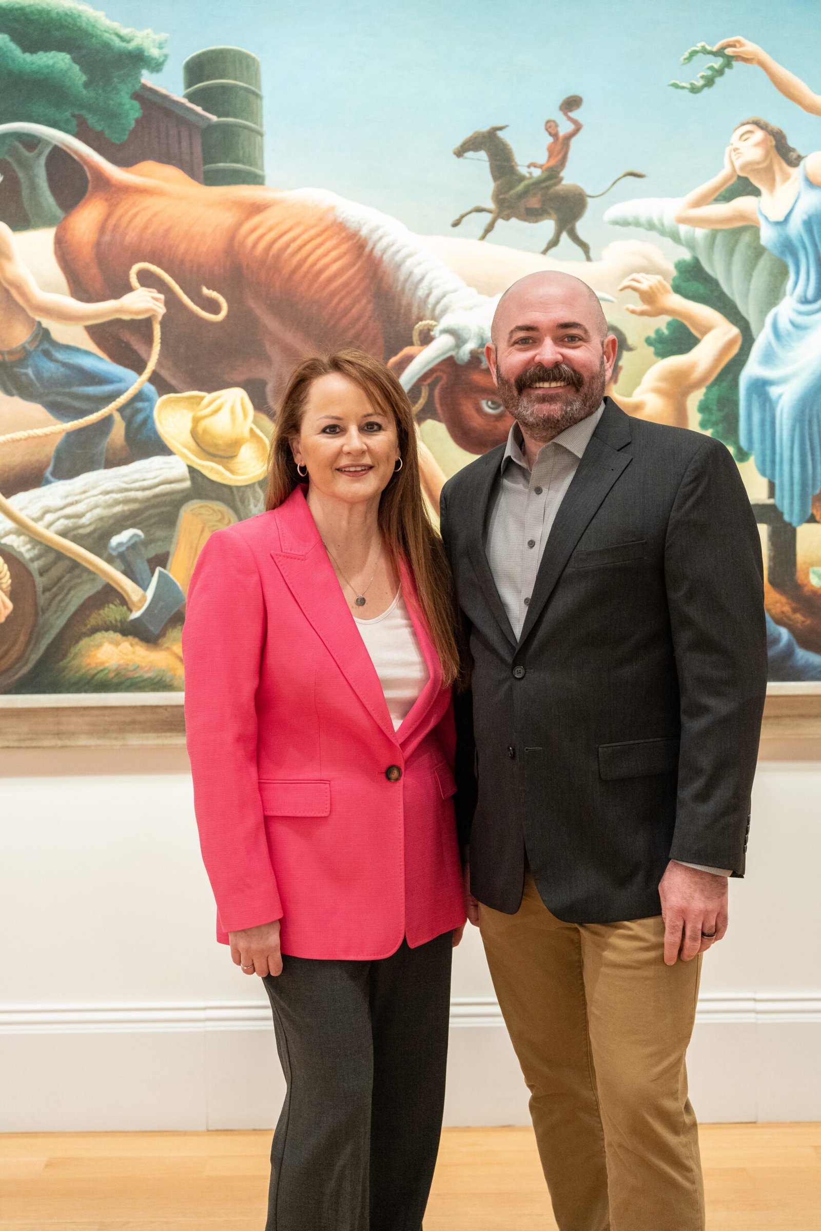Melissa Terzis and Michael Sheridan standing together in front of a vibrant mural.
